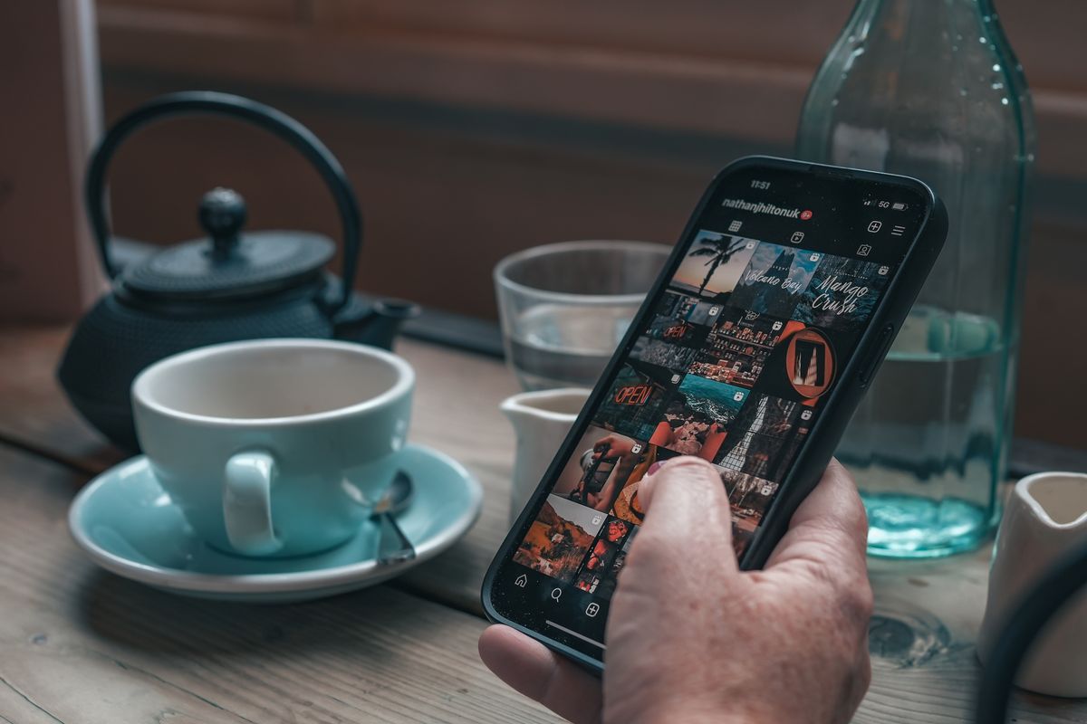 Hand holding a phone with Instagram open
